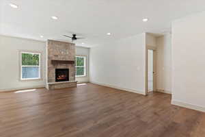 Unfurnished living room featuring wood finished floors, recessed lighting, ceiling fan, and a fireplace