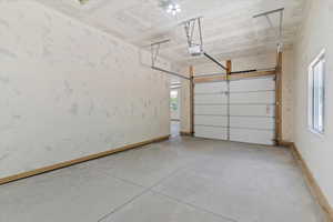 Garage featuring baseboards and a garage door opener