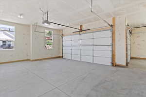Garage featuring baseboards and a garage door opener