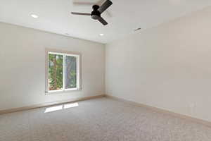 Unfurnished room featuring light colored carpet, a ceiling fan, and recessed lighting