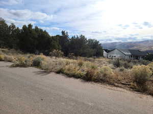View of asphalt street featuring a mountain view