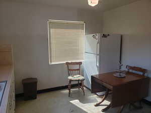 Dining area featuring baseboards and light floors