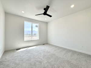 Spare room with carpet floors, a mountain view, and a ceiling fan