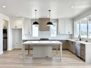 Kitchen featuring light countertops, appliances with stainless steel finishes, a kitchen island, recessed lighting, and decorative light fixtures