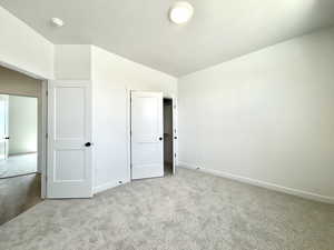 Unfurnished bedroom featuring carpet flooring and baseboards