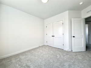 Unfurnished bedroom with carpet floors and a closet