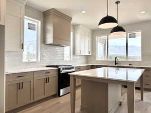 Kitchen featuring stainless steel gas stove, plenty of natural light, light wood finished floors, backsplash, and recessed lighting