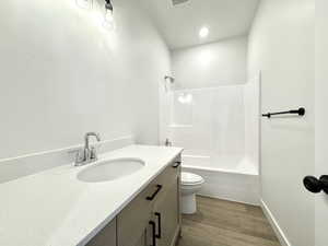 Full bath featuring vanity, wood finished floors, and shower / bathtub combination