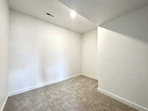 Carpeted empty room with baseboards