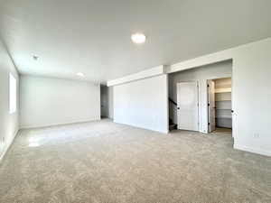 Unfurnished bedroom with carpet, a walk in closet, and recessed lighting