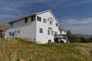 Rear view of property with a wooden deck and stairs