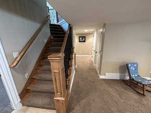 Stairway with carpet floors, a textured ceiling, and recessed lighting