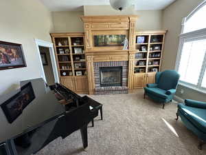 Carpeted living room with a brick fireplace and baseboards