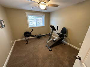 Bedroom being used as an exercise room featuring carpet flooring and a ceiling fan