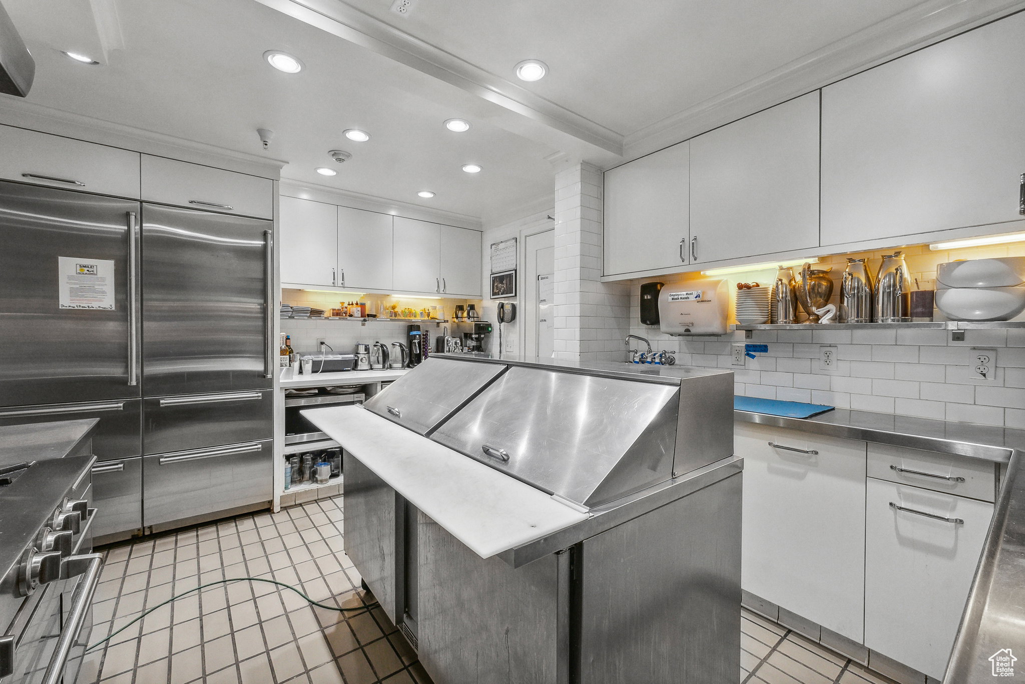 Kitchen with light tile patterned floors, high end appliances, decorative backsplash, white cabinets, and recessed lighting