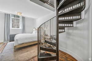 Bedroom with wood finished floors and radiator