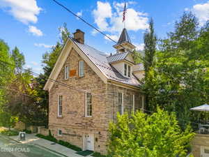 View of side of property with a standing seam roof, a metal roof, and a chimney