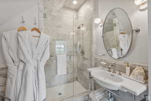 Bathroom featuring a stall shower, decorative backsplash, and tile walls