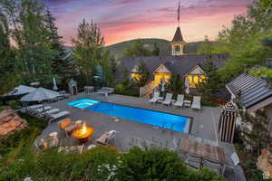 View of pool with a fire pit, a mountain view, a patio area, and outdoor dining area