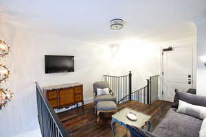 Living room featuring wood finished floors and crown molding