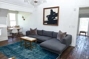 Living area featuring healthy amount of natural light, wood-type flooring, and a chandelier