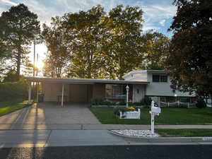 Tri-level home with a front lawn, a carport, and concrete driveway