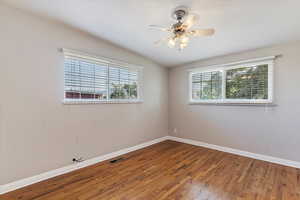 Unfurnished room with wood finished floors and a ceiling fan