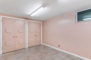 Unfurnished bedroom featuring stone finish floors and multiple closets