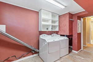 Laundry room with washing machine and clothes dryer and crown molding