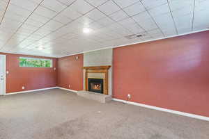 Unfurnished living room featuring carpet and a fireplace