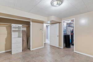 Unfurnished bedroom with baseboards and a walk in closet