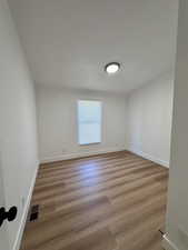 Unfurnished room with light wood-style flooring and baseboards