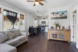 Living area with dark wood-type flooring and a ceiling fan