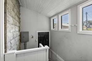 Stairs with electric panel and vaulted ceiling