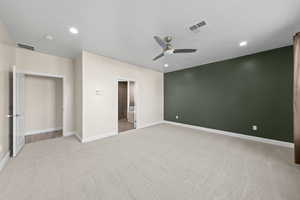 Unfurnished bedroom featuring light carpet, ceiling fan, recessed lighting, and ensuite bath