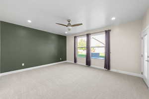 Empty room with light carpet, a ceiling fan, and recessed lighting