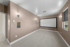 Home theater room featuring light carpet