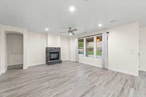 Unfurnished living room featuring light wood-style flooring, recessed lighting, a fireplace, and a ceiling fan