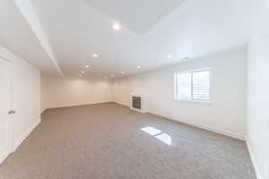 Basement with recessed lighting, light carpet, and a fireplace