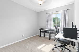 Carpeted office featuring baseboards and a ceiling fan