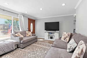 Living area featuring ornamental molding, wood finished floors, and recessed lighting