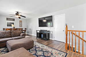 Living room with dark wood finished floors and ceiling fan