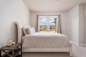 Bedroom featuring carpet floors and baseboards