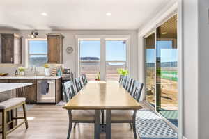 Dining space with light wood-style floors and recessed lighting
