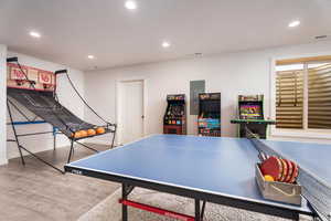 Rec room with recessed lighting, wood finished floors, and electric panel