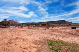 View of yard featuring a rural view, an exterior structure, an outbuilding, and a mountain view