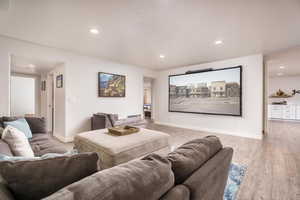 Cinema room featuring light wood-style floors and recessed lighting