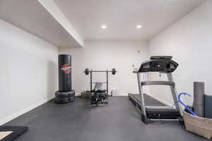 Workout room with a textured ceiling and recessed lighting