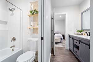 Ensuite bathroom featuring vanity, wood finished floors, and bathtub / shower combination