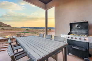 View of patio with an outdoor fire pit, area for grilling, outdoor dining space, and a mountain view